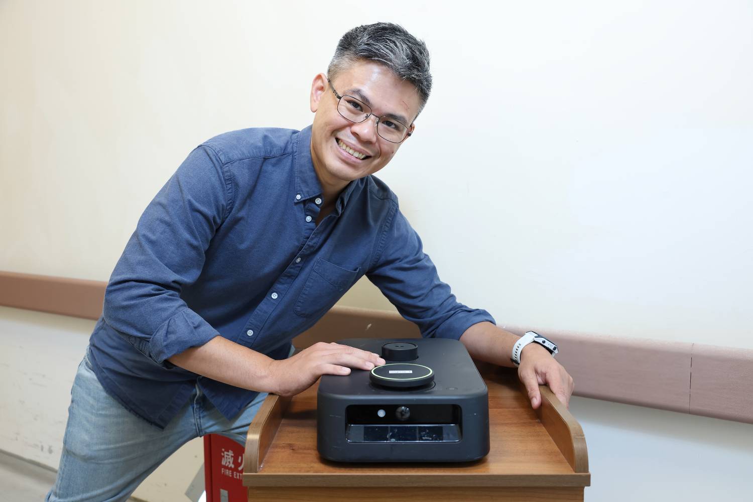 Sigma Robotics founder Snaken with the ~30cm-wide autonomous mobile robot (Image: 經濟部中小及新創企業署 新創採購)